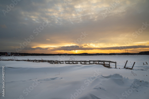 A snowy beach with a sunset in the background