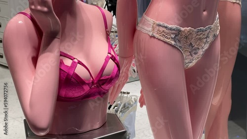 Pink bra and lace panties worn on a woman's mannequins in a lingerie store window