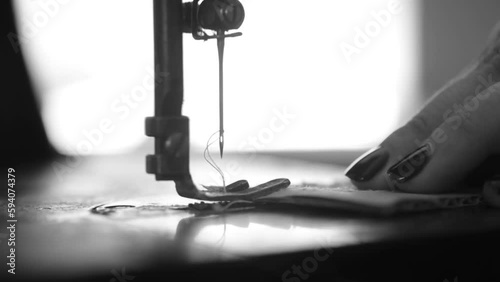 Black and white video where a woman pierces a cardboard with an old fashioned sewing machine. Good footage for video art projects. Macro.