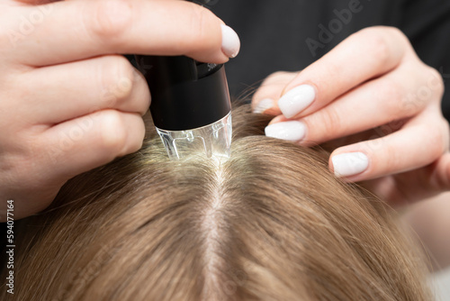 Wallpaper Mural Trichological and dermatological examination of the scalp and hair follicles of a Caucasian female patient in a cosmetology clinic. trichology concept. optical device microscope trichoscope close-up Torontodigital.ca