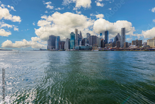 Gorgeous view of Manhattan from river Hudson side. Skyscrapers on blue sky with white clouds background. New York. USA.