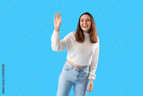 Beautiful young woman wavin...