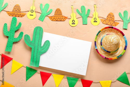 Blank card with paper cacti  garland  flags and sombrero hat on beige background