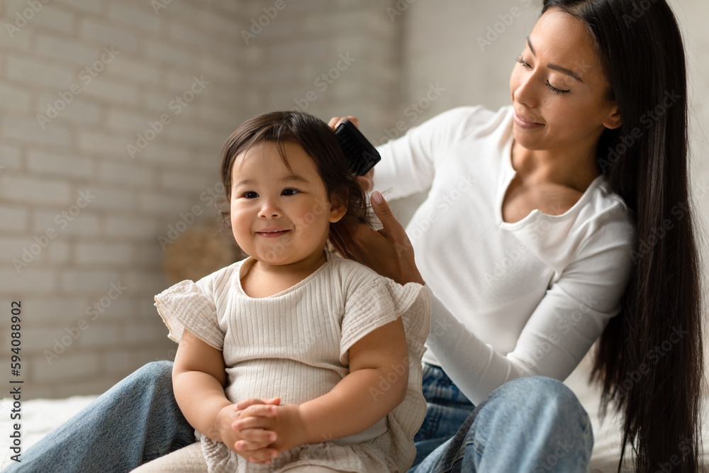 Korean Mom Brushing And Detangling Baby Daughter's Hair In Bedroom Korean Mom Brushing And Detangling Baby Daughter's Hair In Bedroom