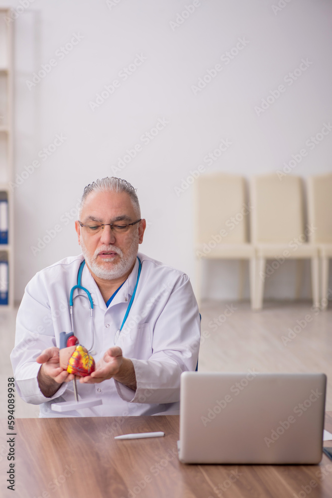 Old male doctor cardiologist working in the clinic Old male doctor cardiologist working in the clinic