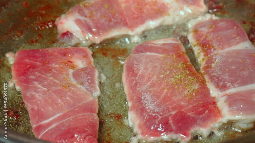 Searing beef bottom round roasted meat in cast iron skillet in boiling
