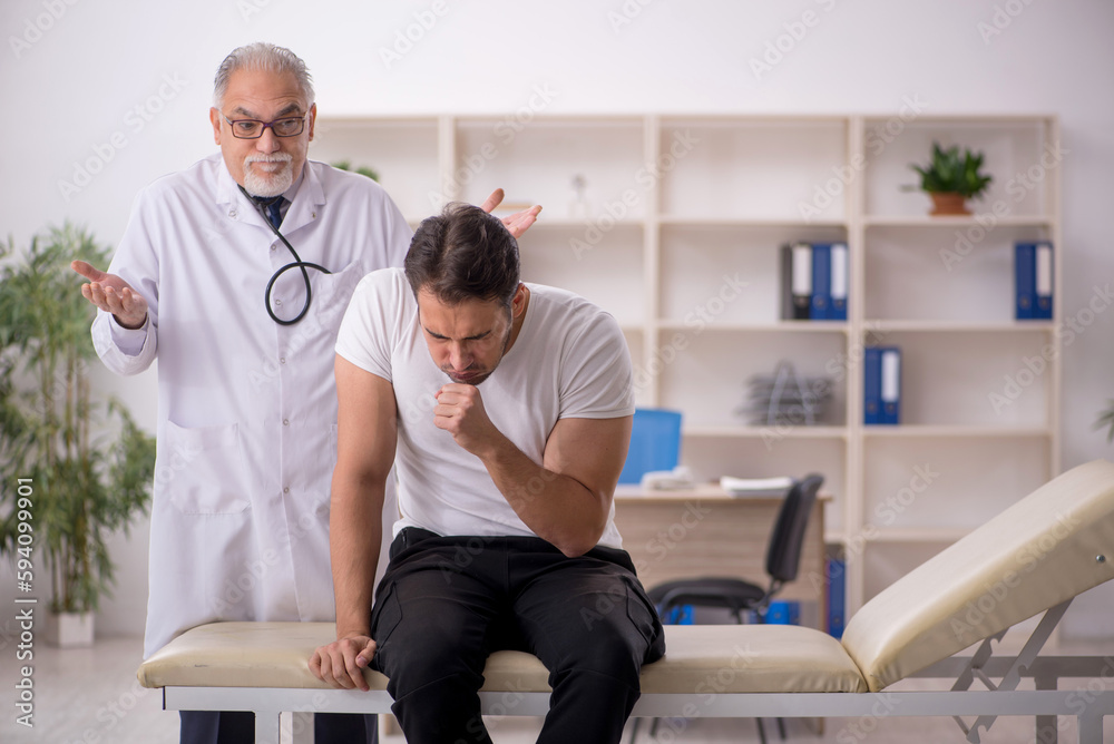 Fototapeta premium Young male patient visiting old male doctor