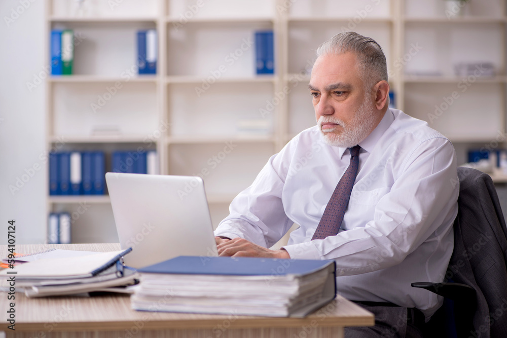 Old male employee working in the office Old male employee working in the office