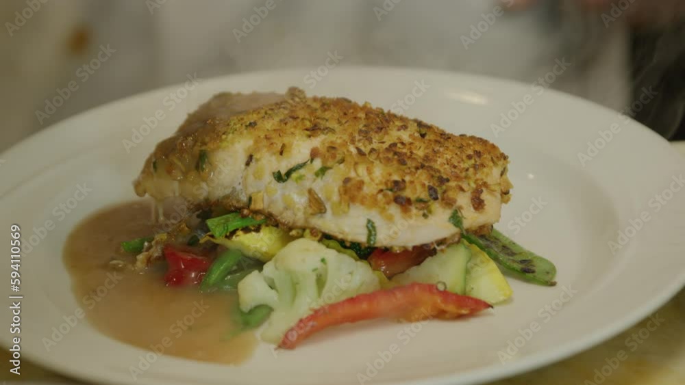 Pouring gravy on fish and vegetable dish Pouring gravy on fish and vegetable dish