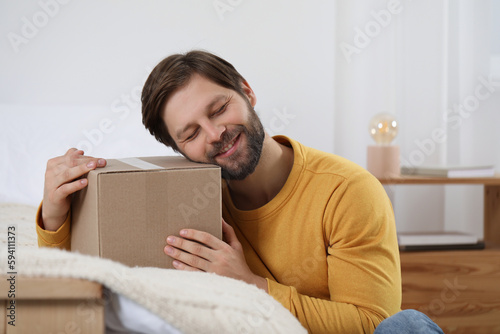 Happy man with parcel at home. Internet shopping