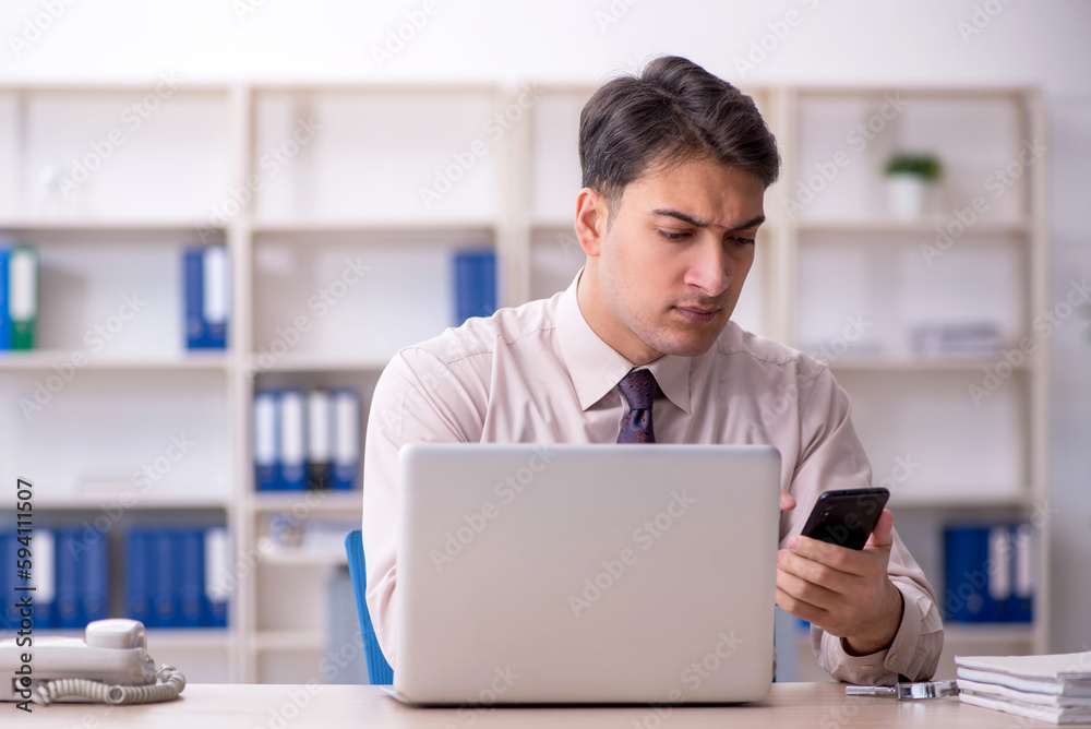 Young male employee working in the office Young male employee working in the office