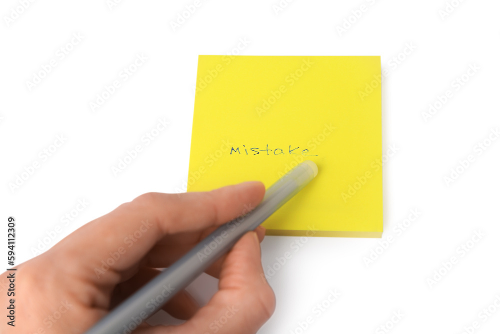 Child erasing word Mistake written with erasable pen on sticky note against white background, closeup