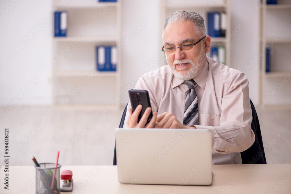 Old male employee working in the office Old male employee working in the office