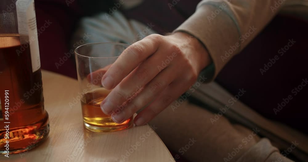 Alcoholic man with an alcohol addiction problem drinking daytime. Want to kill hangover. Binge drinking. Whiskey glass and whiskey bottle Alcoholic man with an alcohol addiction problem drinking daytime. Want to kill hangover. Binge drinking. Whiskey glass and whiskey bottle