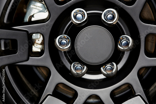 Close up of a Black Car Rim and Tire with Chrome Lug Nuts © Pamela Au