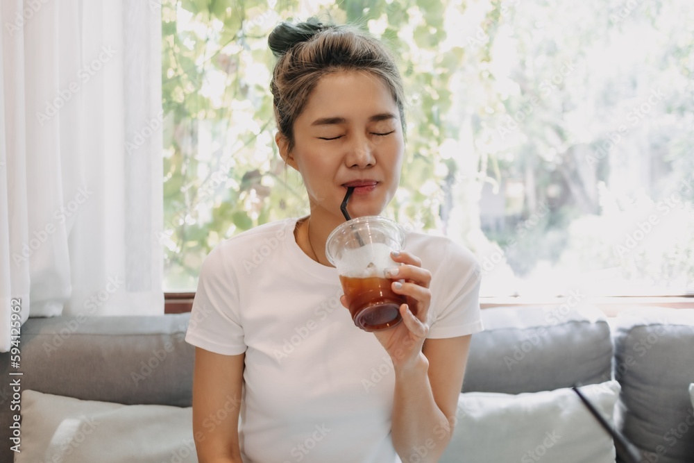 Beautiful and cute asian woman drinking iced coffee in the cafe.