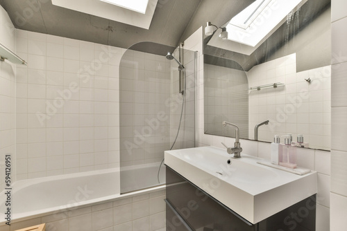 a bathroom with a sink  mirror and bathtub on the wall next to it is a skylight in the ceiling