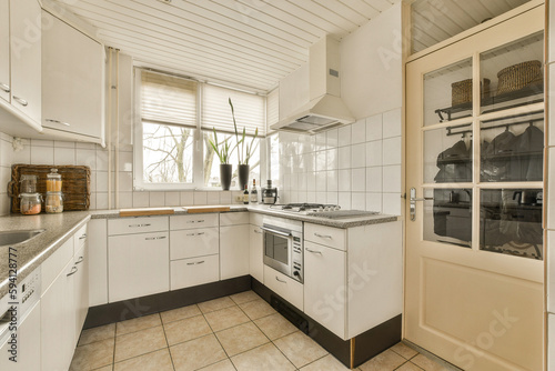 a kitchen with white cabinets and black counter tops on the counters in front of the sink is open to the door