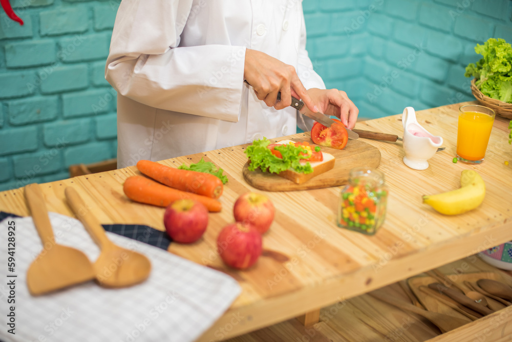 With deft professional the chef sliced through the juicy tomato on the cutting board in a kitchen full of cooking ingredients and a glass of orange juice. With deft professional the chef sliced through the juicy tomato on the cutting board in a kitchen full of cooking ingredients and a glass of orange juice.
