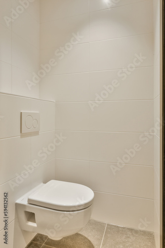 a toilet in the corner of a bathroom stall with white tiles on the floor and walls  all around it