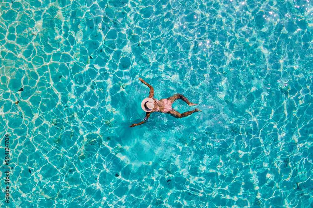 drone view at a woman swimming in the blue turqouse colored ocean of Koh Kradan island in Thailand