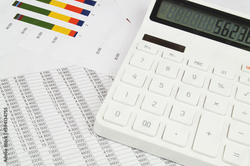 Close up of calculator on financial data papers. Close up of calculator on financial data papers.