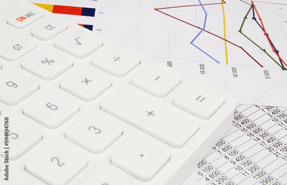 Calculator on financial documents with graphs close-up. Concept of Market analytics and investments. Calculator on financial documents with graphs close-up. Concept of Market analytics and investments.