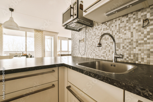 a kitchen with black and white tiles on the backs  counter tops  and sink fauced in it
