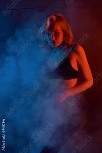 Attractive woman in sexy black lingeri in smoky room