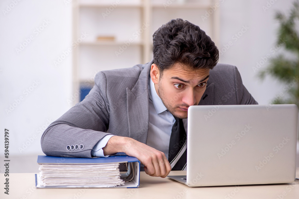 Young male employee working in the office Young male employee working in the office