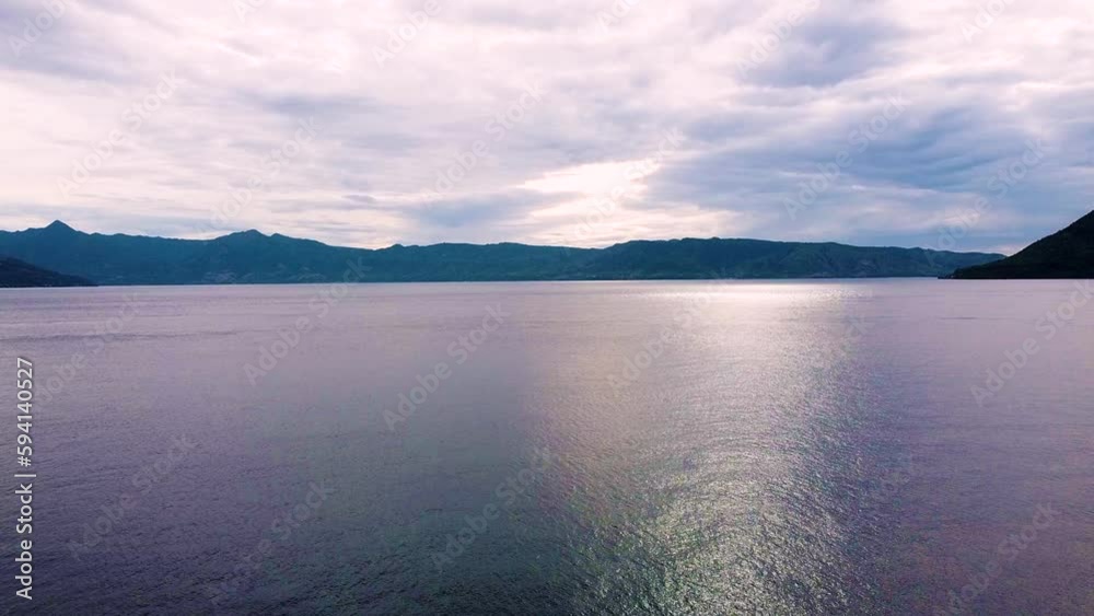 Aerial drone rising over ocean with twilight pink and purple hazy sunset in Alor Island, East Nusa Tenggara, Indonesia Aerial drone rising over ocean with twilight pink and purple hazy sunset in Alor Island, East Nusa Tenggara, Indonesia