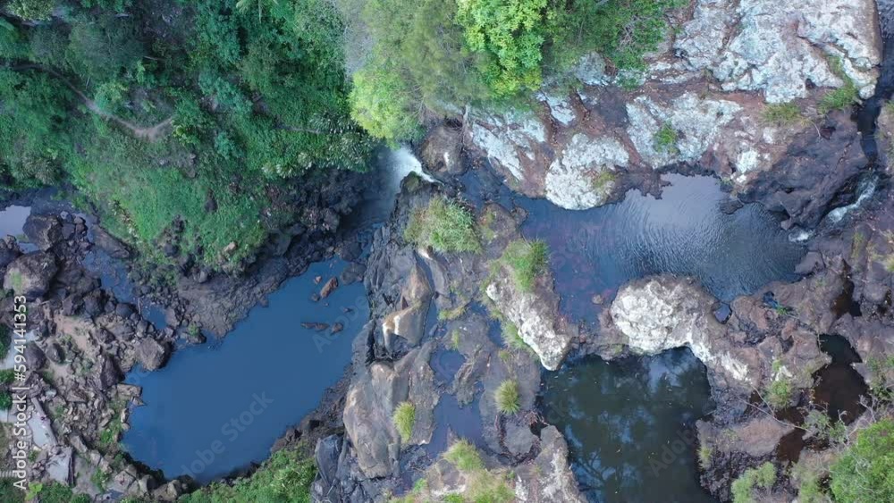 Top down drone shot over Purling Brook Falls, camera flying above waterfall, slowly revealing the large waterfall. Top down drone shot over Purling Brook Falls, camera flying above waterfall, slowly revealing the large waterfall.