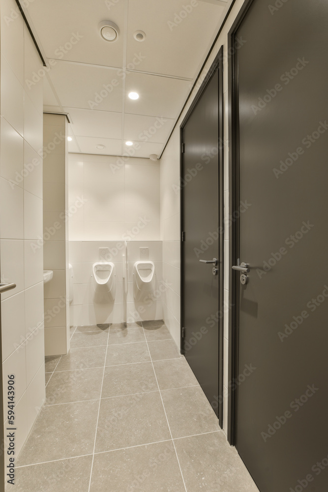 a bathroom with two toilets in the middle and one on the other side there is an open door that leads to another room a bathroom with two toilets in the middle and one on the other side there is an open door that leads to another room