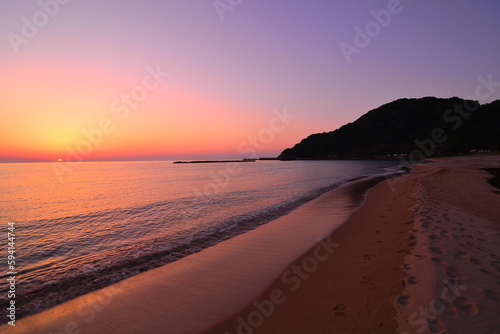 美しい海岸の夕陽が水平線に沈む風景です。