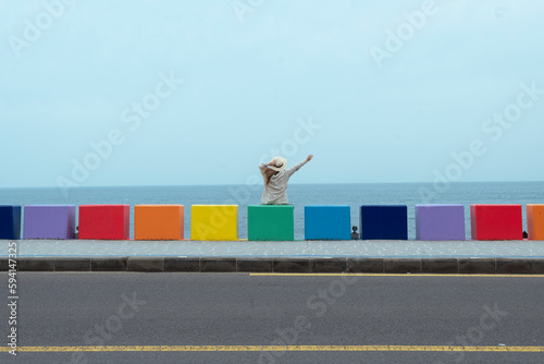 Lady tourist travel at Dodu-dong Rainbow Coastal Road in Jeju Island, Korea.
