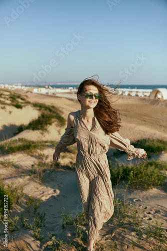 stylish woman, in summer, walks on the coast in windy weather enjoying vacation