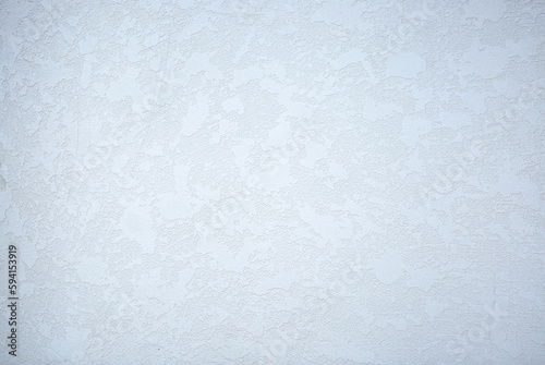 Light background of decorative plaster with abstract spots. Unusual texture of white or gray wall with beautiful patterns, creative surface background. Finishing coating for building cladding.