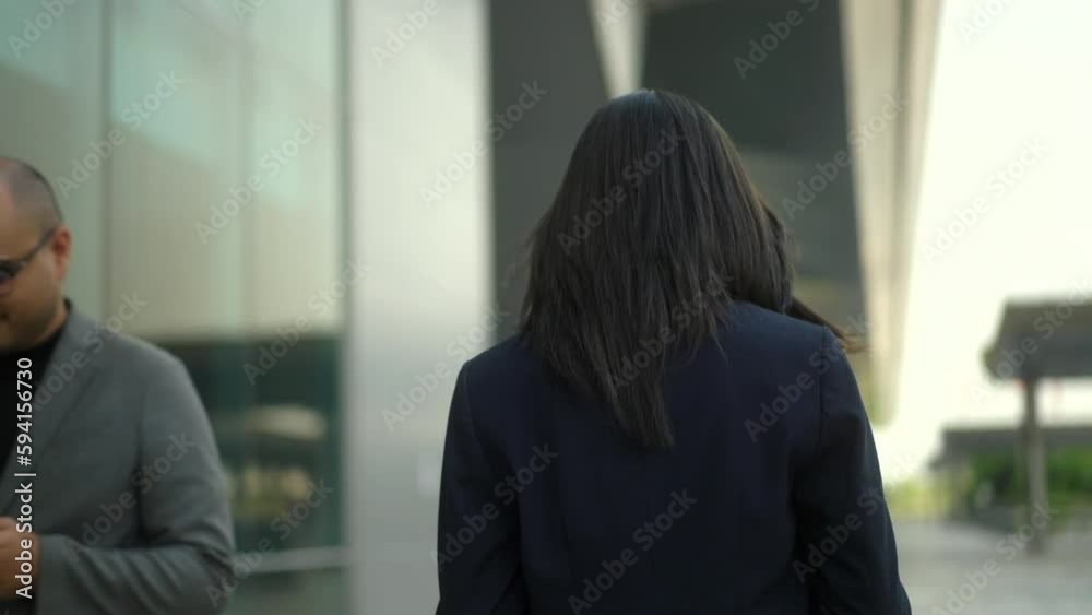 Business people walking and using smartphone application to communication at city business buildings. Successful attractive woman using cell phone in front modern office building. Working woman.
