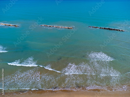 Obraz na płótnie Aerial view landscape Italy Pescara. Empty beach and sea, waves, sand, rocks. Photo from a drone. Blue sky. w salonie