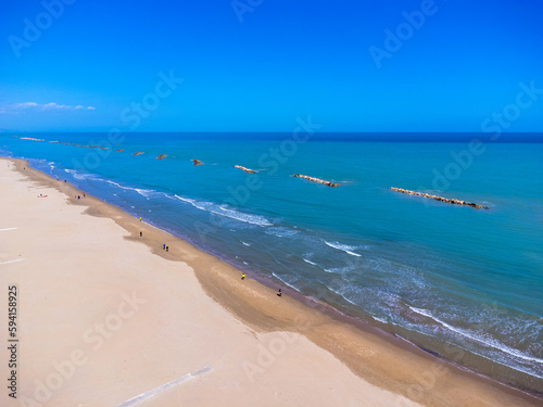 Obraz na płótnie Aerial view landscape Italy Pescara. Empty beach and sea, waves, sand, rocks. Photo from a drone. Blue sky. w salonie