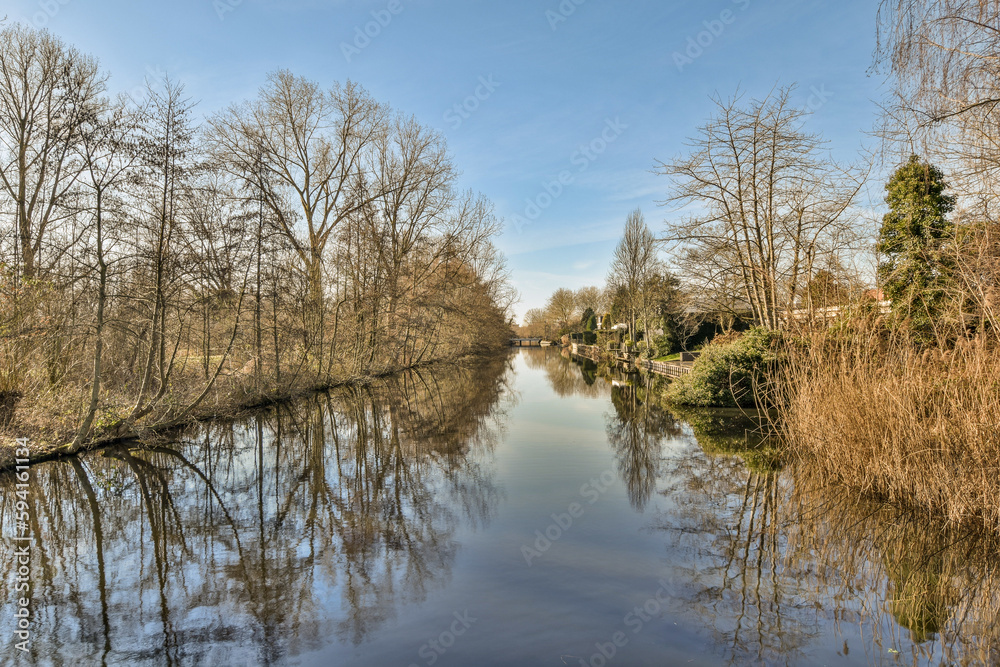 a river with trees and bushes in the fore, taken from a bridge over it's waterline on a sunny day a river with trees and bushes in the fore, taken from a bridge over it's waterline on a sunny day