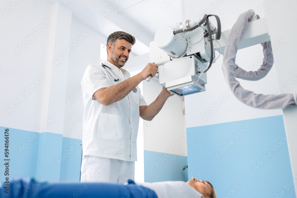 Multiethnic radiologists with young female patient in xray room