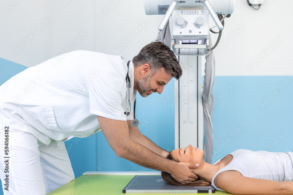 Obraz premium In the Hospital, Low Angle Shot of Woman Lying on a Bed, Male Technician adjusts X-Ray Machine. Scanning for Fractures, Broken Limbs, Injuries, Cancer or Tumor. Modern Hospital