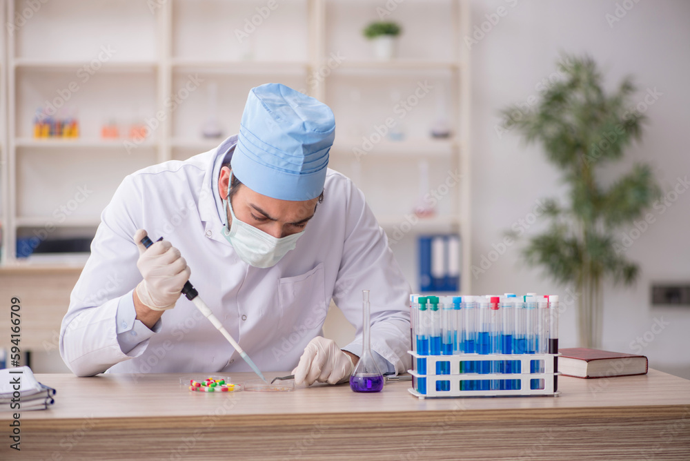 Young male chemist working at the lab Young male chemist working at the lab
