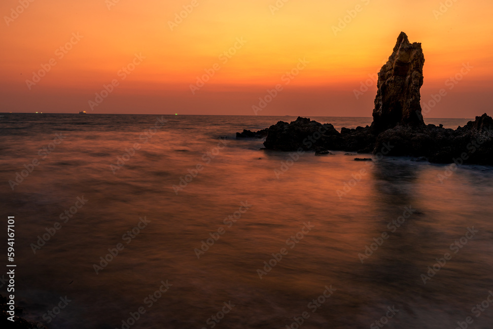 The background of the sea by the evening sea, with natural beauty (sea water, rocks, sky) and fishermen are fishing by the river bank, is a pleasure during travel.