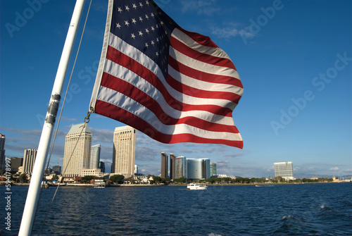 large American flag waving in SanDiego Bay overlooking the city photo