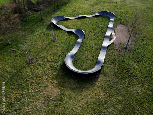 bike path in the car park Pumping (moving up and down) is used instead of pedaling and bouncing to move bicycles, scooters, skateboards and inline skates along the modular pumptrack track, oval, drone photo