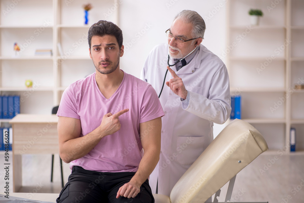 Obraz premium Young male patient visiting old male doctor