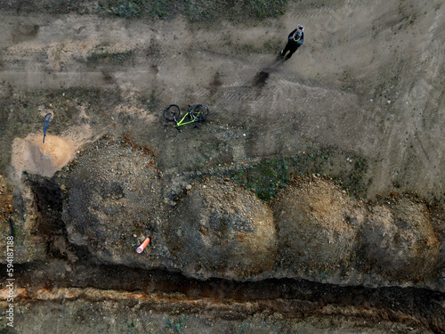 defaultsewer excavations and piles of earth at the construction site documentation with drone photos operator. rows of trenches are mapped by a fast messenger on a bicycle. sewer pipe, upper view © Michal