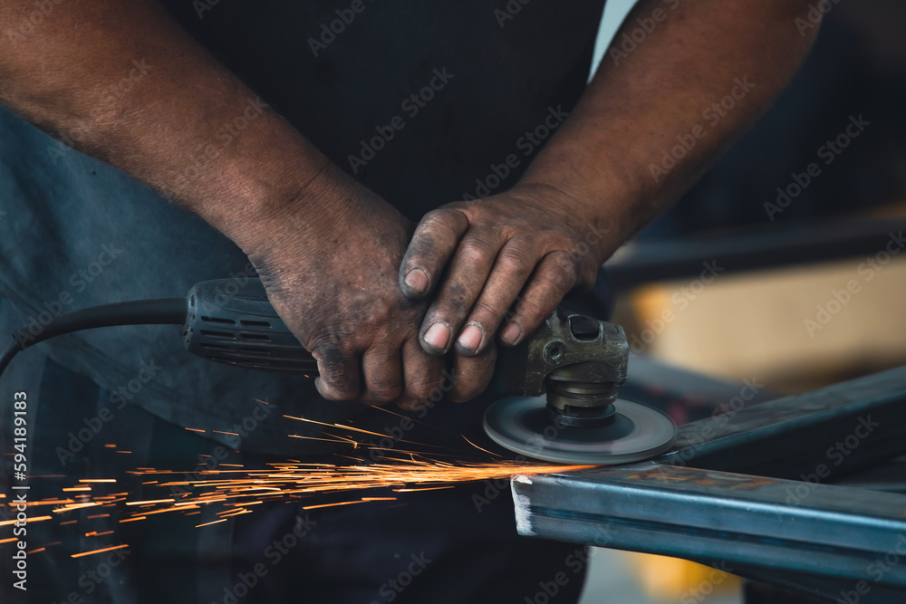 Close up on a man held an angle grinder to cut an iron with sparks Close up on a man held an angle grinder to cut an iron with sparks